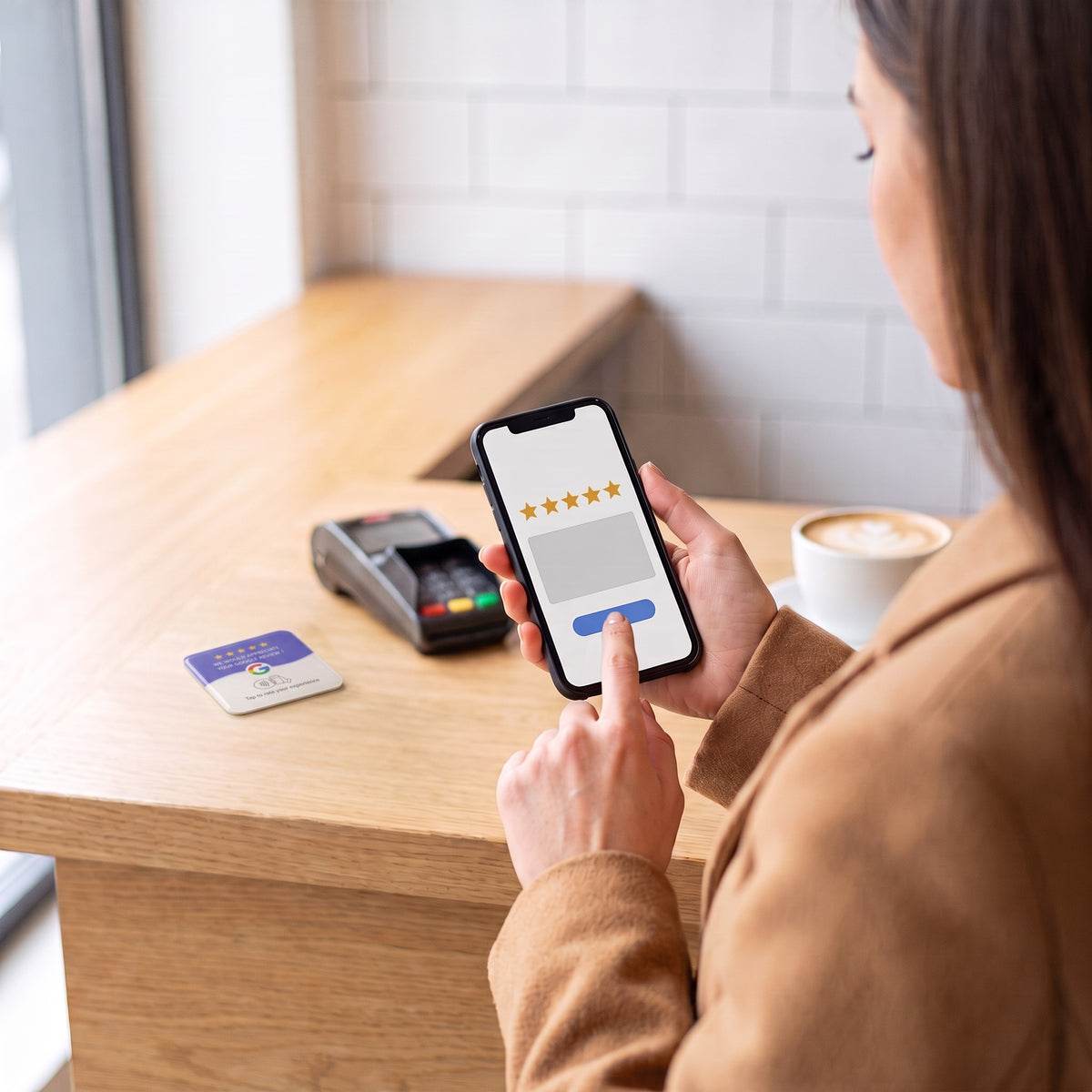 Kundin gibt am Handy eine Sternebewertung ab, die NFC-Karte liegt auf der Theke | English