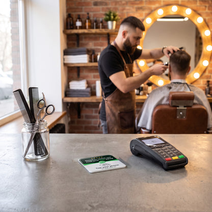 WhatsApp-NFC-Karte auf dem Tresen eines Barbershops neben dem Kartenterminal | English