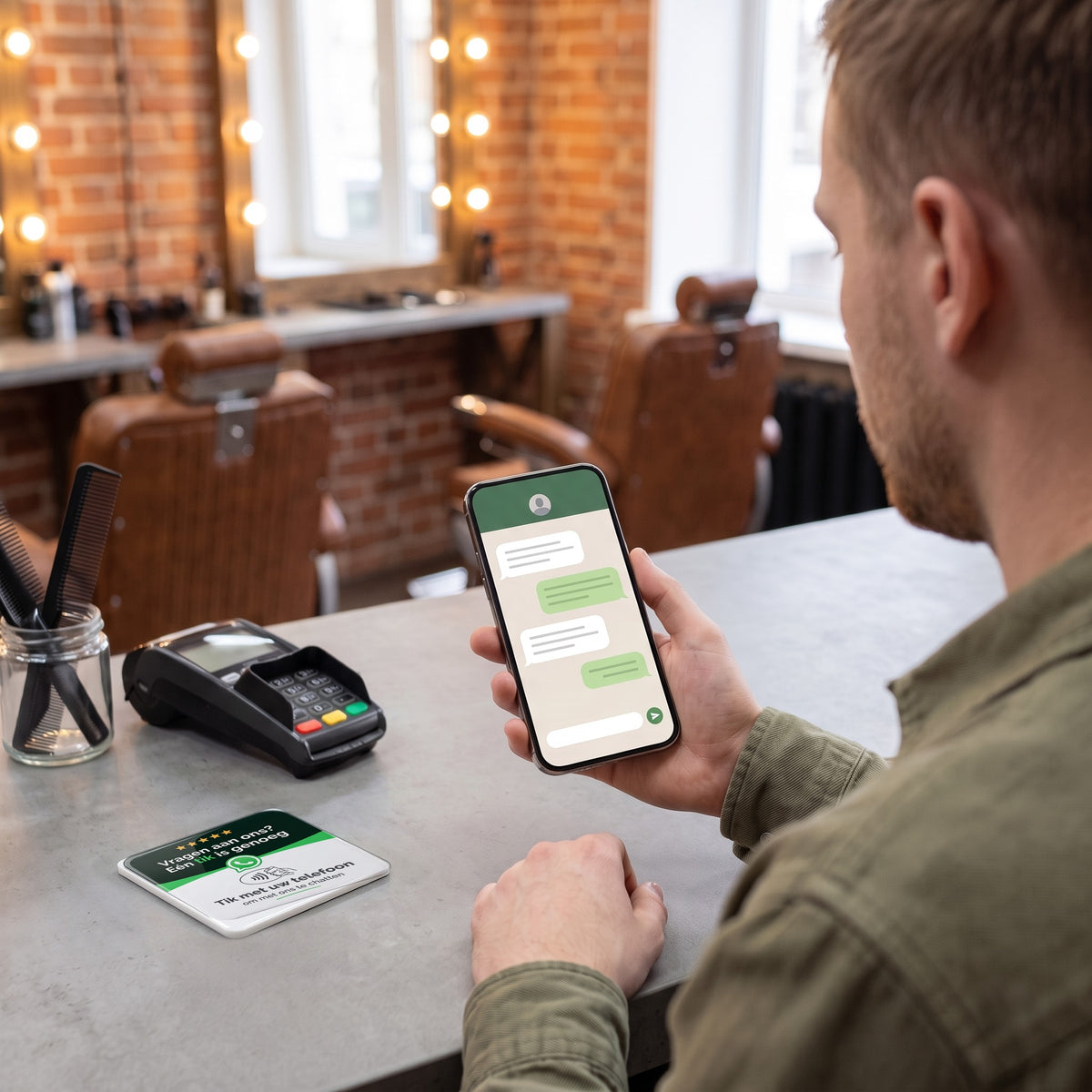 Kunde schreibt am Handy eine Nachricht, die NFC-Karte liegt auf dem Tresen | Nederlands